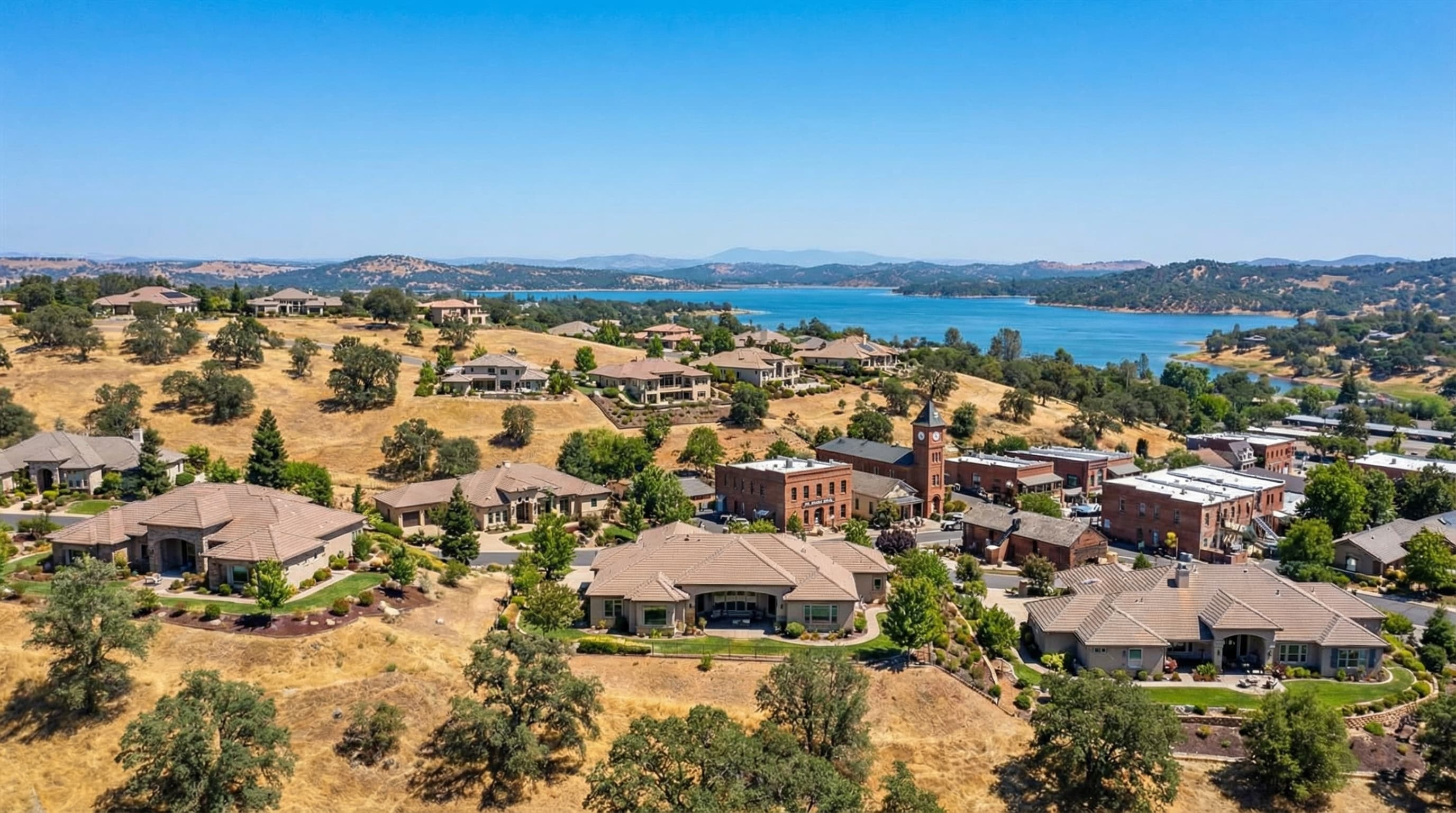 Scenic Folsom California with Folsom Lake backdrop, upscale homes on rolling hills, historic Old Town charm, on a bright sunny California day